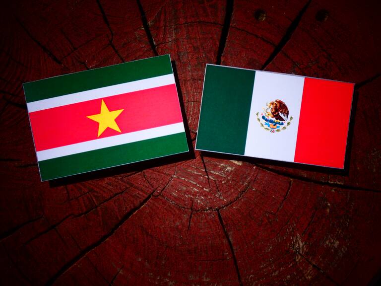 Suriname flag with Mexican flag on a tree stump isolated