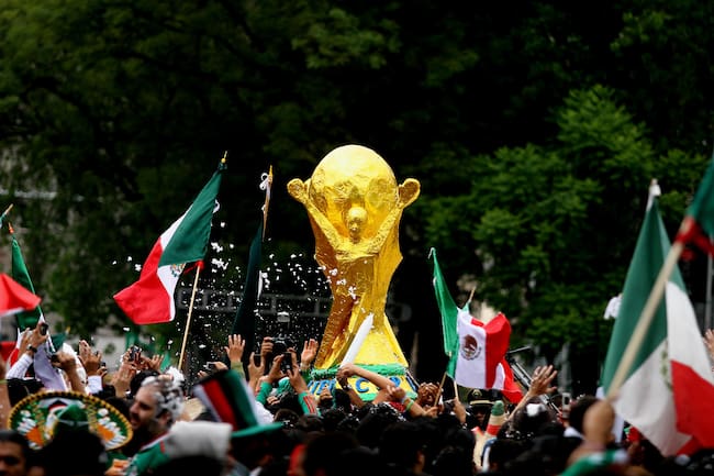 Aficionados mexicanos cargan un trofeo gigante de la Copa Mundial de la FIFA 2010 durante el partido entre México y France, como parte del Mundial de 2010